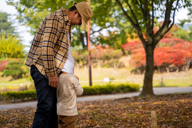 男の子がお父さんの服で顔を隠している