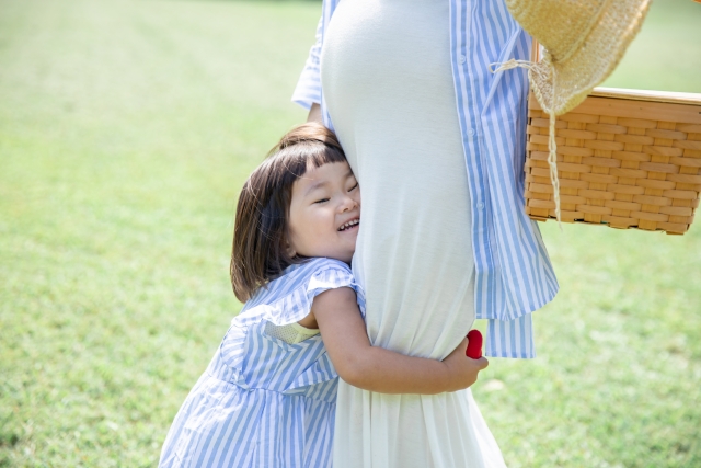 妊娠しているママに抱きつく女の子