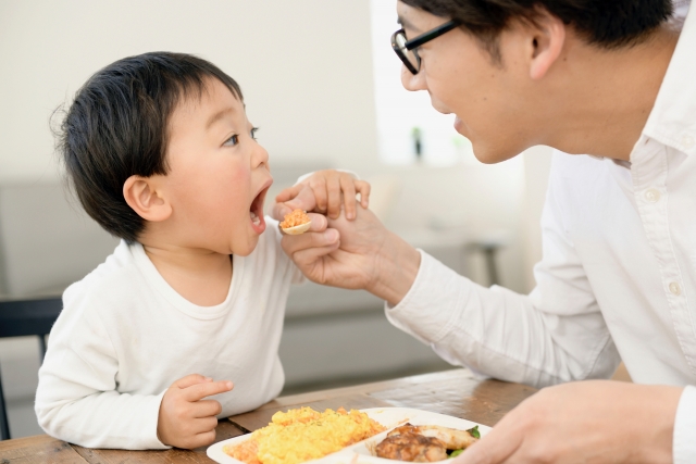 子供にご飯を食べさせるお父さん