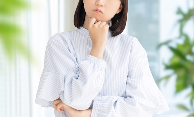 悩んで首をかしげる女性