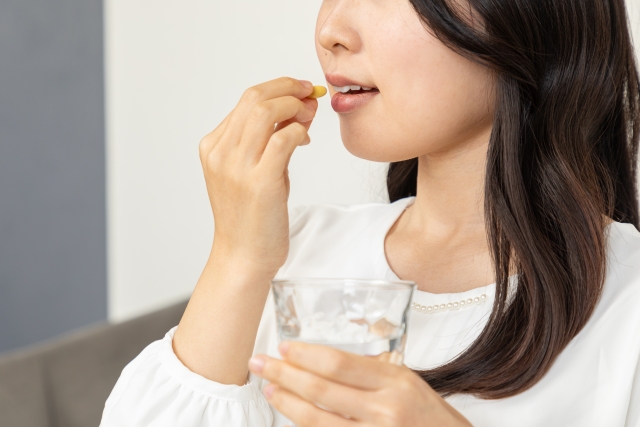 薬を飲む女性