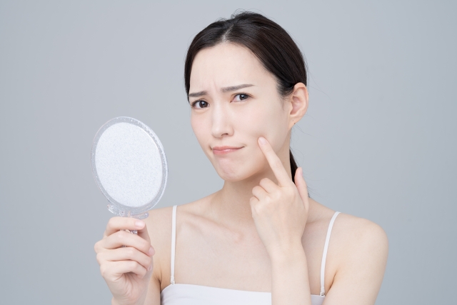 鏡を見て悩む女性
